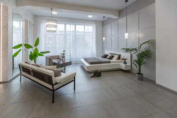 stylish bright modern bedroom interior with decorative niches with LED lighting and a huge panoramic window in gray and white colors and geometric shapes