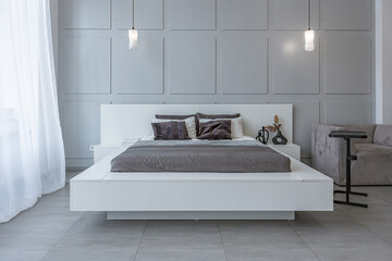 stylish bright modern bedroom interior with decorative niches with LED lighting and a huge...