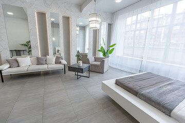 stylish bright modern bedroom interior with decorative niches with LED lighting and a huge...