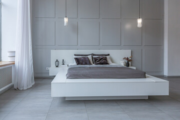 stylish bright modern bedroom interior with decorative niches with LED lighting and a huge...