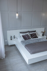 stylish bright modern bedroom interior with decorative niches with LED lighting and a huge...