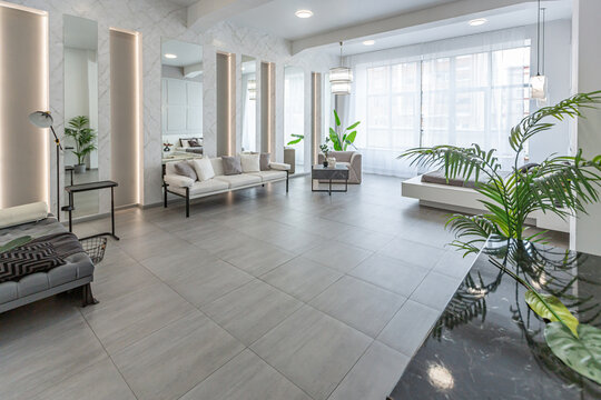 stylish bright modern bedroom interior with decorative niches with LED lighting and a huge panoramic window in gray and white colors and geometric shapes