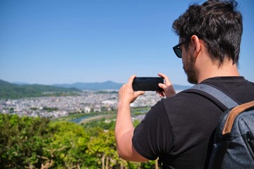 Tourist taking a photography of Kyoto city view from Arashiyama Monkey Park Iwatayama in Kyoto, Japan.
