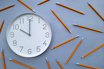 10 o'clock, morning. Study time. Back to school. Watch with white clock face on blue table background with pencils. Concept of study, workday, deadline, schedule.  Online work and Distance learning