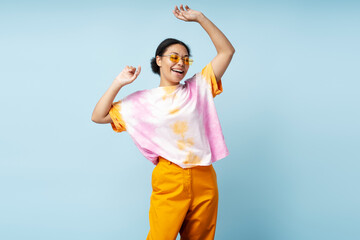 Portrait of beautiful happy African American woman dancing wearing trendy tie dye t shirt isolated...