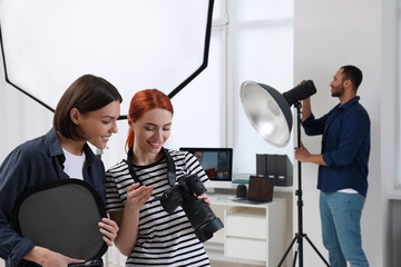 Young professional photographers working in modern photo studio - Powered by Adobe