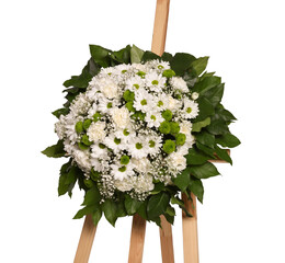 Funeral wreath of flowers on wooden stand against white background