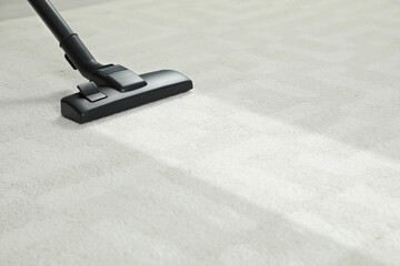 Hoovering carpet with vacuum cleaner, space for text. Clean trace on dirty surface