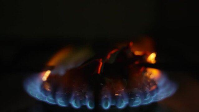 Ashes from burnt paper on a gas burner. Slow motion. Dolly shot
