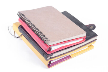A stack of notebooks with a black and yellow cover and a brown bookmark on the top