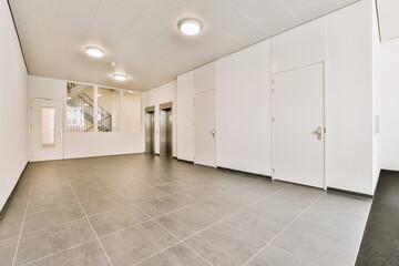 an empty room with white walls and grey flooring in the middle of the room, there are two doors on either sides