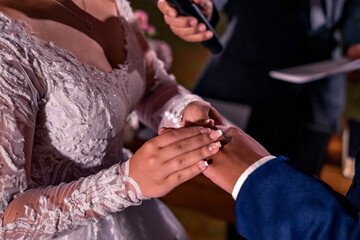 the hands of a wedding couple exchanging rings