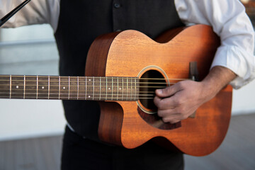 Fototapeta na wymiar Professional guitarist plays guitar outdoors. Musician plays a classical guitar in the park.