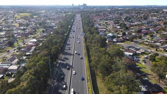 Aerial drone view above the South Western M5 Motorway at Casula in Sydney, NSW Australia with Liverpool CBD in the background 