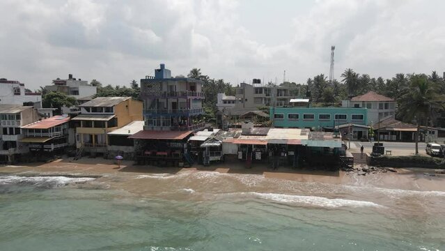 Aerial view: Ramshackle waterfront buildings on Sri Lanka coast sand