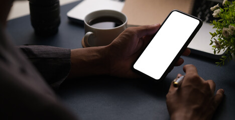 Man hands holding smart phone with blank screen for your text message or information content.