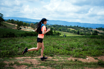 Young women active trail runners the top of a mountain in the afternoon, ultra marathon runners...