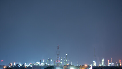 Lights shine from the buildings of the industrial estate area at night. Free space of clear sky at...