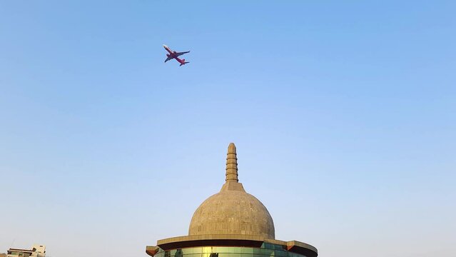 buddha stupa with airplane crossing by and bright blue sky at morning from different angle video is taken at buddha park patna bihar india on Apr 15 2022.