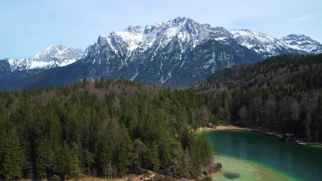 Fly away drone shot, showing the Lauter Lake in summer with Karwendel mountain in the background, very close to the bavarian town of Mittenwald in Germany