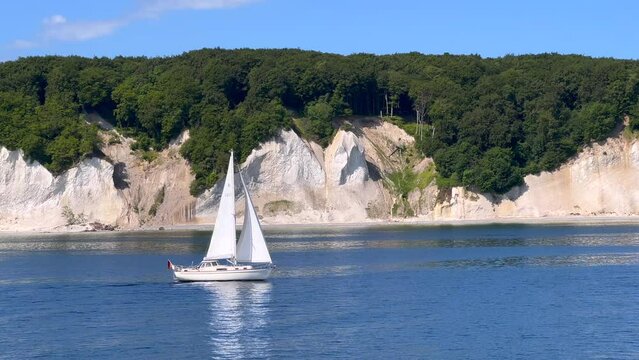 The very famous chalk cliffs of the R&uuml;gen Island in Germany, viewed from the baltic sea, with a small passing sailboat