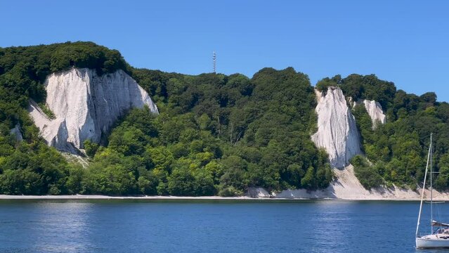 The very famous chalk cliffs of the R&uuml;gen Island in Germany with the K&ouml;nigsstuhl vantage point, viewed from the baltic sea, with a small passing sailboat