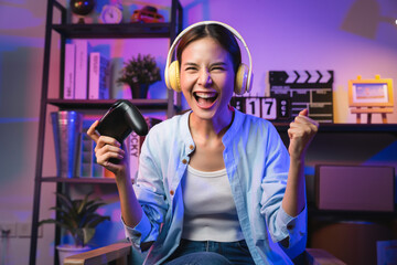 Excited Young Asian woman holding joysticks with playing online game. - obrazy, fototapety, plakaty