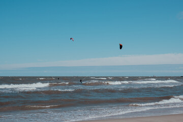 Wing Foiling kitesurfing wind surfing water outdoor sport in Baltic sea Dark blue clouds ocean water surface with foam waves before storm, dramatic seascape background. 