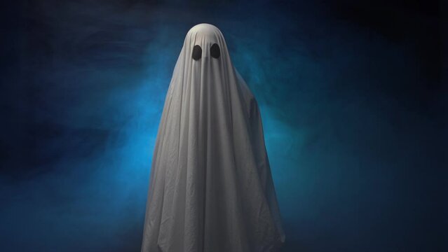 Ghost in white sheet over smoke background, looking at camera
