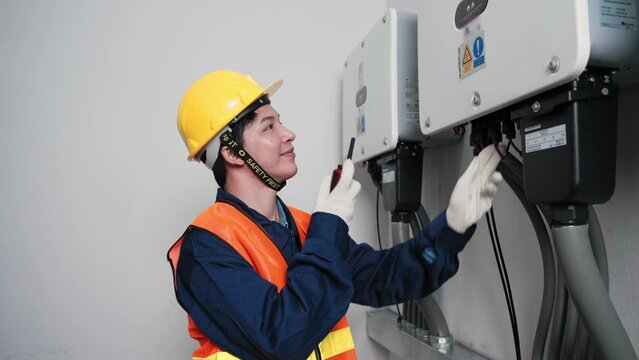 Asian technical engineer man checking circuit board repair and maintenance panel control electricity system of solar cell in electrical distribution room, Repair and Maintenance concept