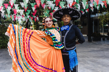 Latin couple of dancers wearing traditional Mexican dress from Guadalajara Jalisco Mexico Latin America, young hispanic woman and man in independence day or cinco de mayo parade or cultural Festival