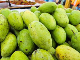 Close-up Fresh of Green Mango (Ma-Muang). Organic Mangoes pile from local agriculture farm. The pile of Mango at the market in Thailand. 