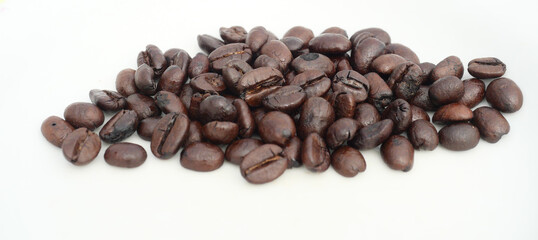 Pile of Dark brown roasted coffee beans isolated on white background, Raw processed food for drinks refreshment