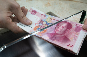 exchanging RMB china yuan at counter. money currency exchange.