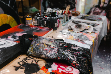 Artist studio table smeared with paint blobs and smudges.