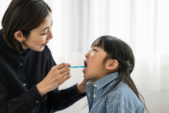 子供の歯磨きをする母親