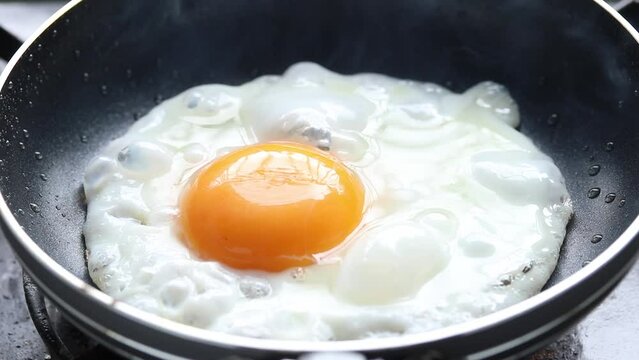Cooking fried eggs in frying pan. Close-up shot 
