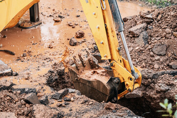 an excavator has dug a hole and is bailing out water after an accident in the underground water...