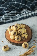 cake ball with chocolate on topping. indonesian cake or cookies. served on wooden place map in grey and texture background. inscription 