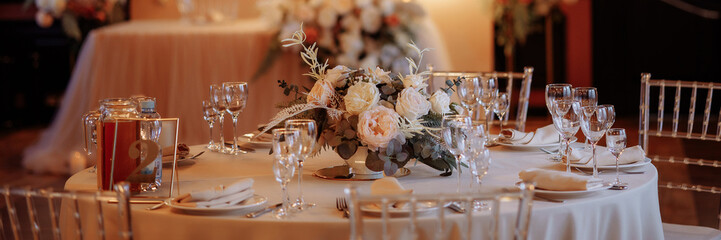 Decoration of the wedding table, evening atmosphere. Preparing for dinner. Garlands over the table. High quality photo. Banner for website header design with copy space.