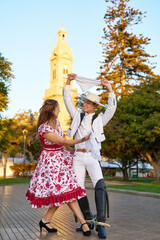 portrait young adult latin american couple dancing cueca with huaso dress in the city square