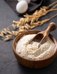 Organic baking ingredients. Oatmeal and eggs  on a dark  background close up. Concept of homemade and healthy food