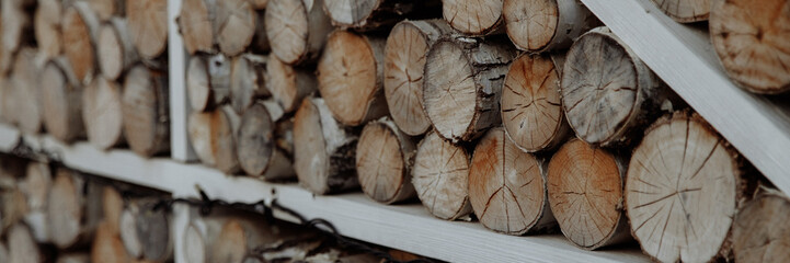 A wall made of timber trunks, abundant in wood and soil. Banner for website header design with copy space.