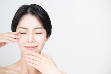 美容やスキンケア、エステに使いやすいアジア系（日本人）女性　眼を閉じた顔のアップ	目元や口元のパーツを触れる