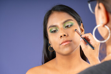 Applying powder with a brush on a young woman