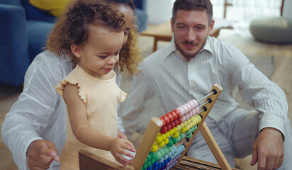 Obraz premium Father, Mother and daughter are doing play a toy and having fun in living room.