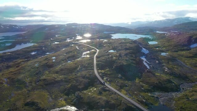 Car driving on mountain road seen from drone's aerial view in Norway