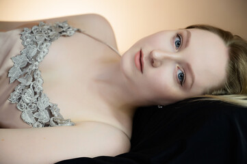 Naklejka premium Calm young woman with blue eyes on pillow.