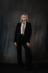Fototapeta premium Portrait of a modern stylish caucasian woman wear classik black suit isolated on black