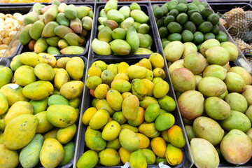 Fresh ripe tasty mangoes are sold on the market in boxes